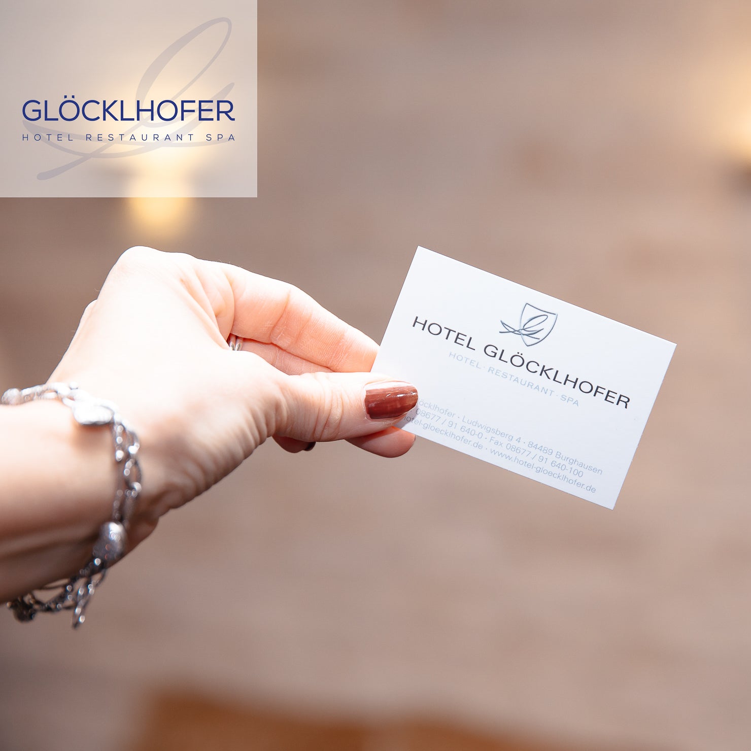 Hochwertige Visitenkarte von GLÖCKLHOFER - Hotel, Restaurant, Spa in Burghausen wird in die Kamera gehalten – Fokus auf Papierstruktur und edles Finish – geschmacksRaum® WERBEAGENTUR
