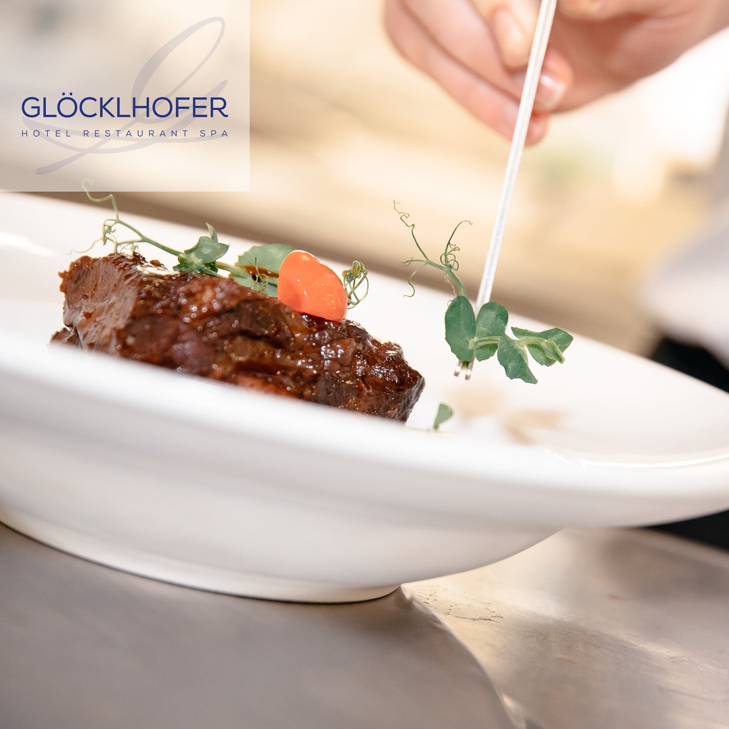 Atmosphärische Food-Photography und Interieur-Design im Restaurant Glöcklhofer - Koch zelebriert das Anrichten einer Fleischspeise – Visuelles Marketing von geschmacksRaum® WERBEAGENTUR